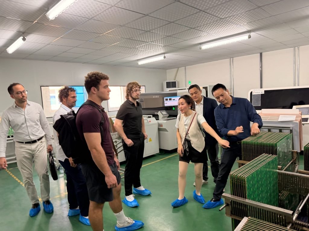 Executives on a China business tour walking a factory floor